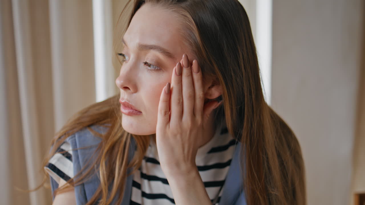 Depressed girl massaging temples sitting apartment closeup. Portrait of sad lady
