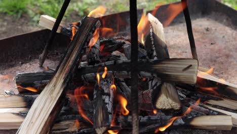 close up view of fire burning under tripod for cooking utensils, looping static clip