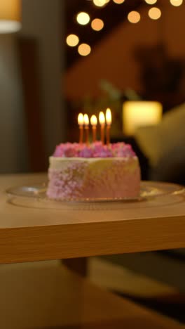 Vertical-Video-Of-Party-Celebration-Cake-For-Birthday-Decorated-With-Icing-And-Candles-On-Table-At-Home-1