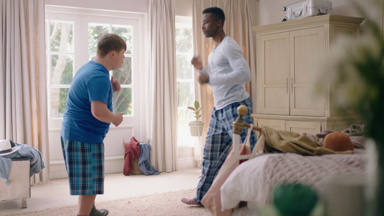 행복한 아버지가 십대 아들과 함께 춤을 추고 재미있게 놀이 춤을 즐기고 집에서 피자마를 입고 주말을 즐기고