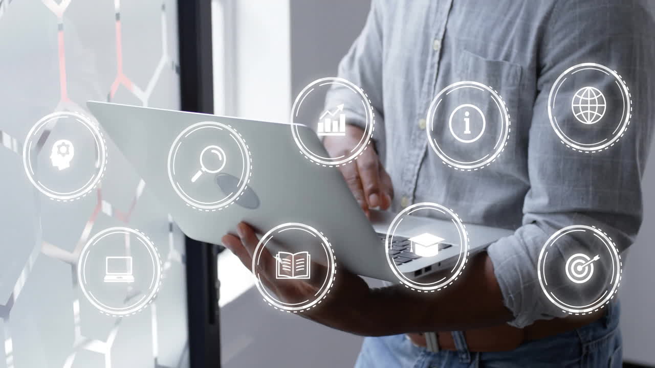 animación de iconos sobre hombre de negocios afroamericano usando portátil en la oficina