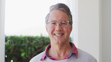 Video-portrait-of-happy-senior-caucasian-man-in-glasses-smiling-to-camera-at-home