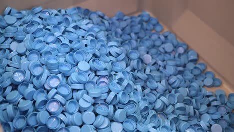 un montón de tapas de botella de plástico. las tapas azules caen de arriba a abajo