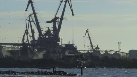 Kohlenverladung-Im-Hafen-Von-Liepaja,-Arbeitende-Kräne-Im-Hafen-Bei-Sonnigem-Tag,-Sichtbares-Meer,-Totale