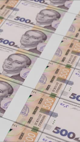 vertical video of 500 ukrainian hryvnia banknotes printed by a money press