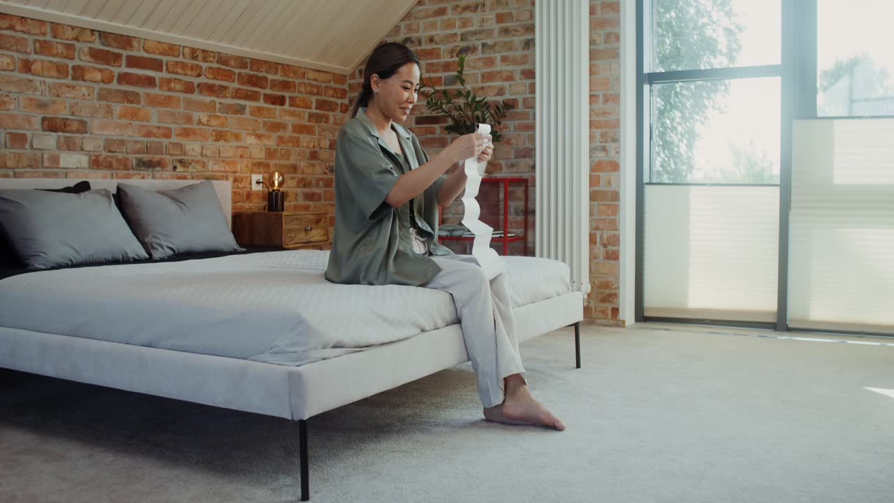 mujer revisando muestras de tela en un dormitorio moderno