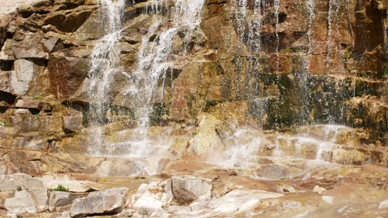belle cascade d'une falaise dans la forêt. vidéo 4k de l'eau qui coule, le ruisseau qui coule entre les pierres. ruisseau dans la forêts