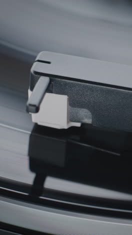 close-up of a record player needle on a spinning vinyl record