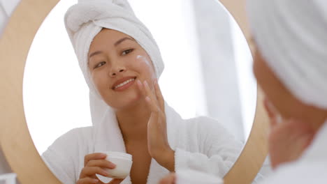 mujer aplicando crema facial
