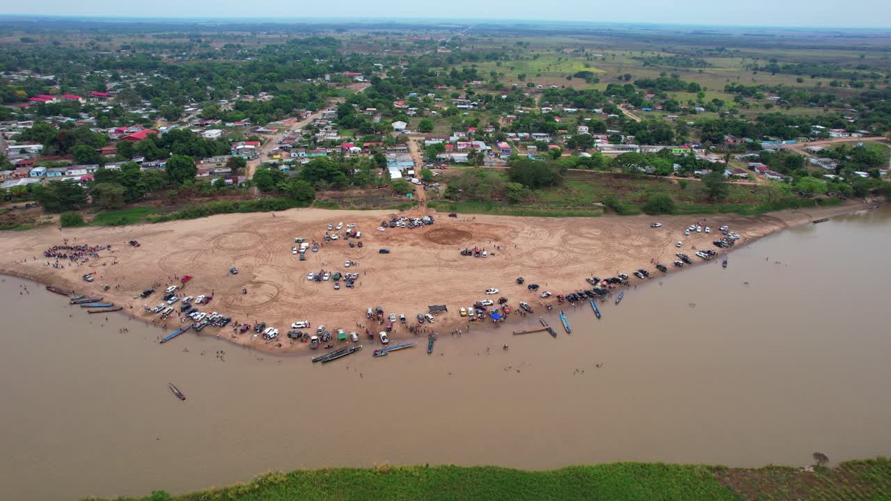 People and Boats on a Sandy Riverbank in Venezuela