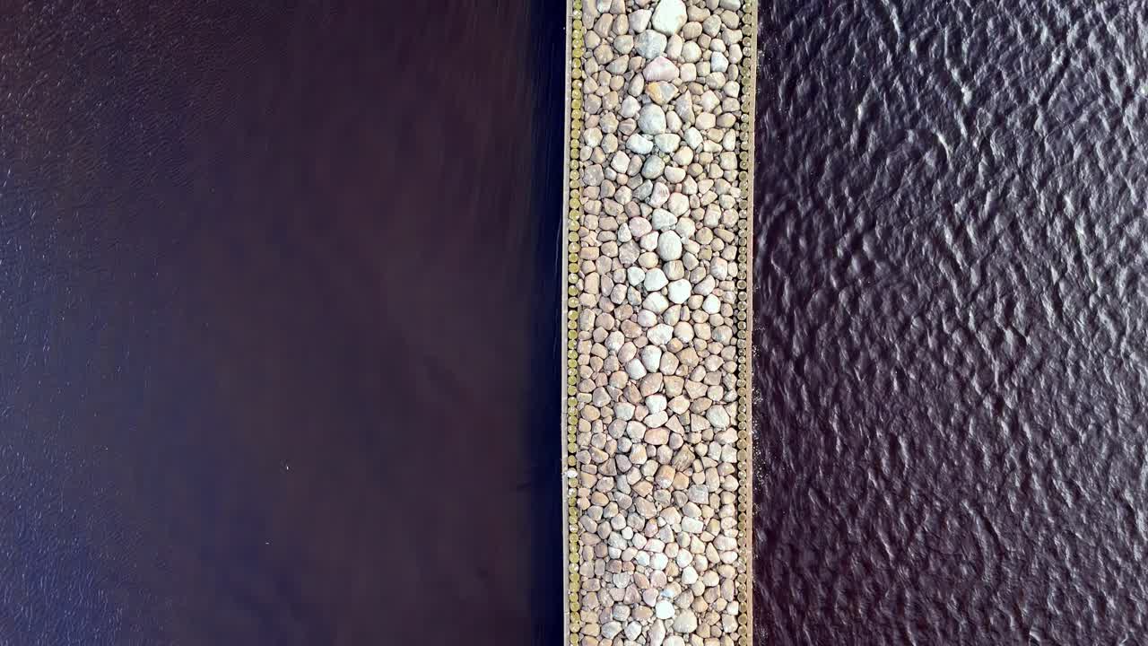 vista aérea de un largo muelle de madera que sobresale en un océano azul claro