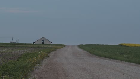 tranquil scene with a road and a farmhouse in poland, static wide shot