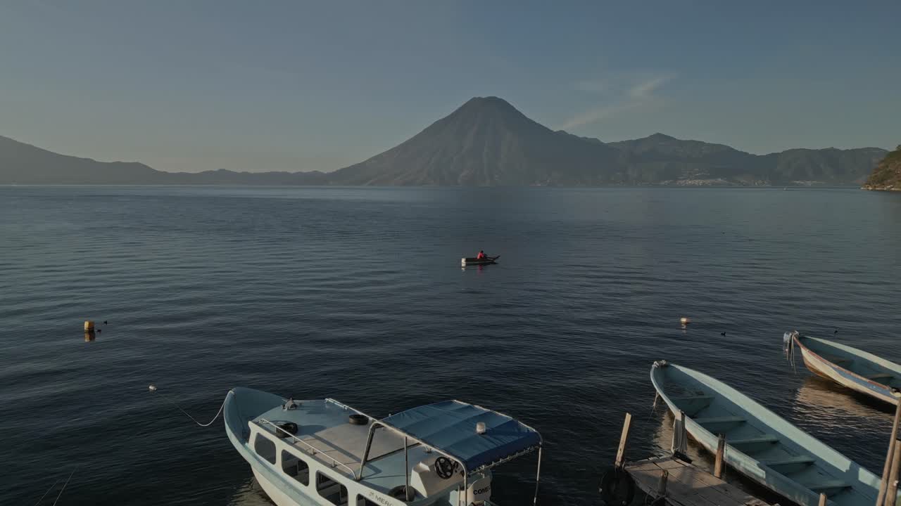 Optagelser viser det smukke vand i Atitlán-søen, med både der vugger blidt langs kysten. Optaget fra forskellige vinkler, der fanger de omkringliggende bjerge og klare himmel.