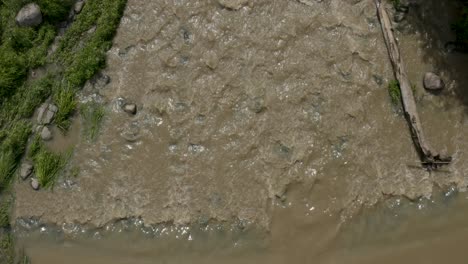 Top-down-aerial-view-of-a-muddy-Keravanjoki-River-near-Kerava,-Finland