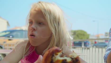 girl eating a sweet pastry outdoors