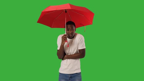 man holding umbrella and shivering with cold