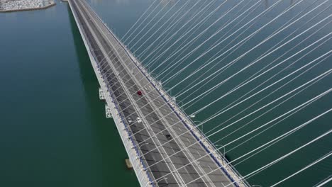 aerial view of a cable-stayed bridge over a bay with cityscape