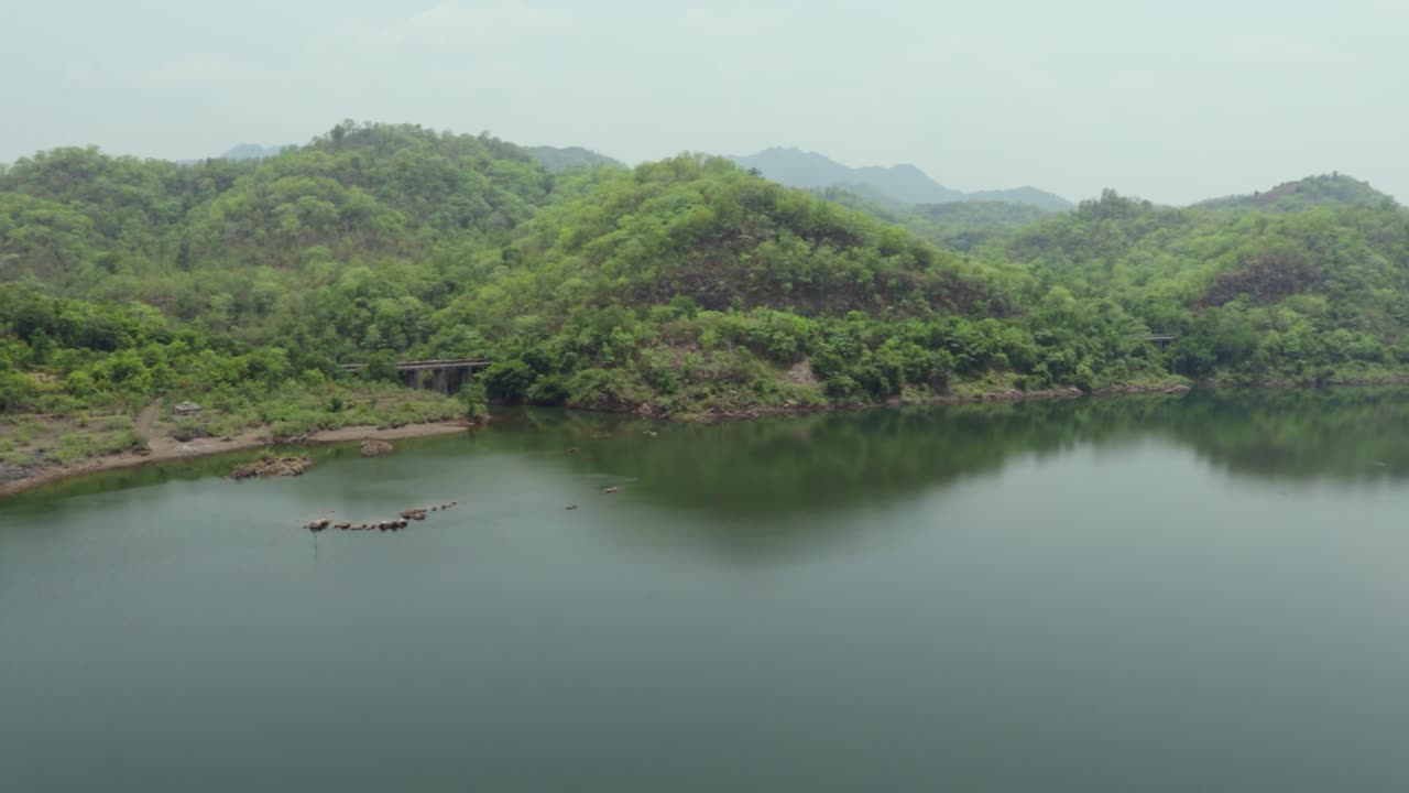 montaña verde con el reflejo del agua del río por la mañana desde un ángulo plano