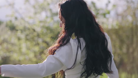 joyful-lady-in-white-dress-is-dancing-in-blooming-garden-in-spring-morning-happiness-and-freedom