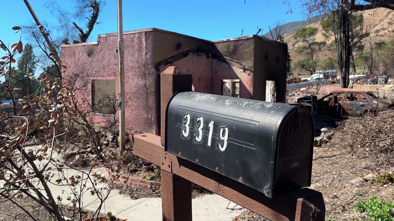 Handheld close-up panning shot of the shell of a burned-out home in the aftermath of the Eaton Fire in Altadena, California. 4K