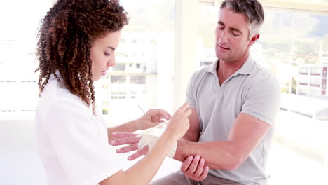 Doctor-bandaging-her-patient-hand