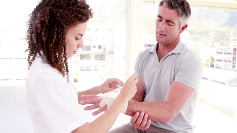 el médico vendando la mano del paciente