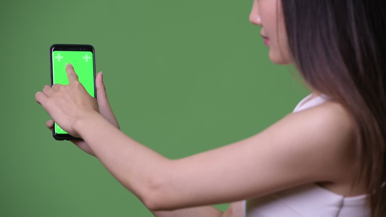 젊은 아름다운 아시아 사업가 여성이 전화를 보여주고 있습니다.