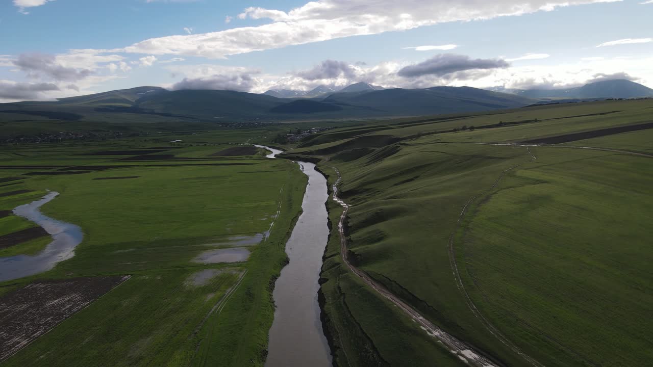 fotografía aérea de un río rodeado de prados pueblos casas antiguas montañas