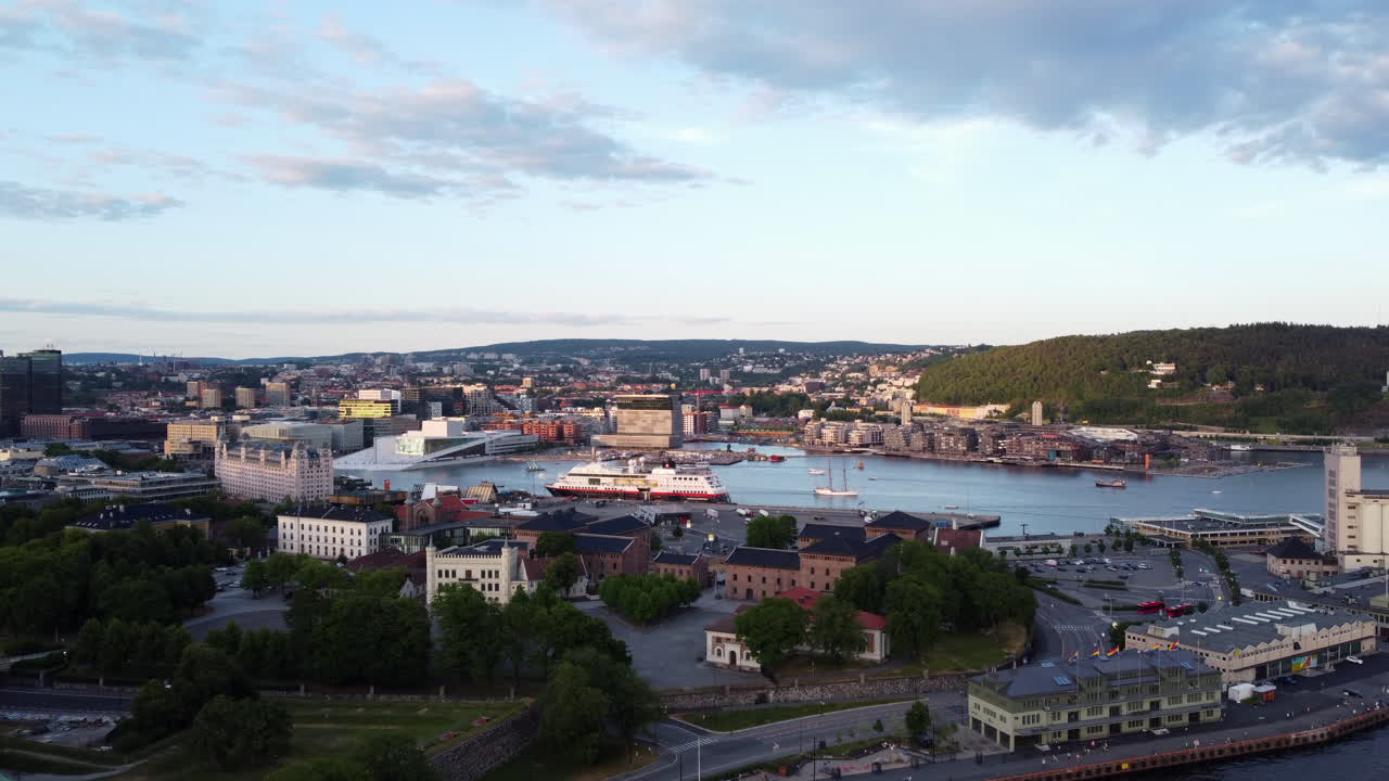 Vista aérea sobrevolando el casco antiguo de Oslo hacia un transatlántico.