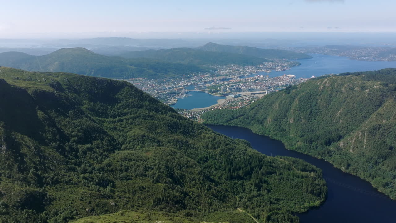 Aerial pull-out shot of Vidden, showing the plateau, fjords, and surrounding mountains under a sunny sky