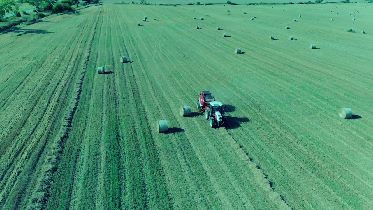 Trattore che pressa rotoballe in Bulgaria, luglio 2018, drone che filma intorno