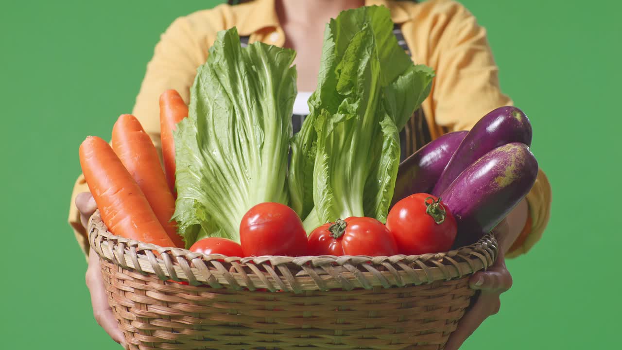 mujer sosteniendo una canasta de verduras frescas