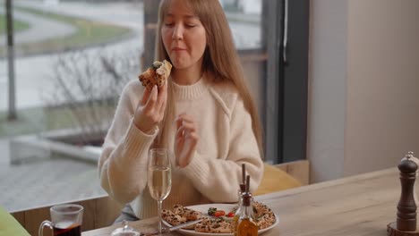 woman eating pizza in a cafe