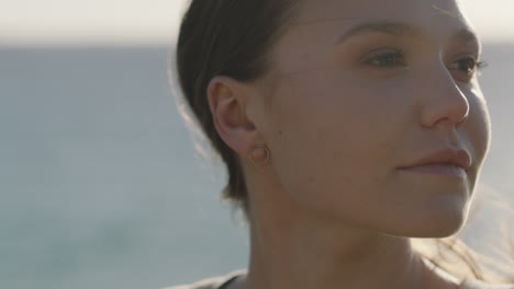 close-up-portrait-of-beautiful-young-woman-enjoying-calm-peaceful-summer-day-looking-relaxed-pensive-caucasian-female-in-ocean-seaside-background