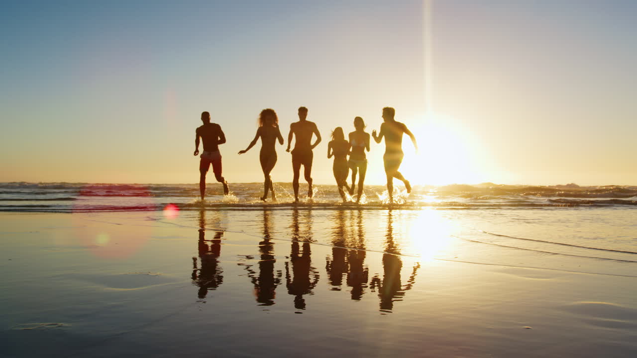 해가 지는 날 해변 휴가 에서 파도 를 가로질러 달리는 친구 들