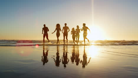 Freunde-Laufen-Im-Strandurlaub-Bei-Sonnenuntergang-Durch-Die-Wellen