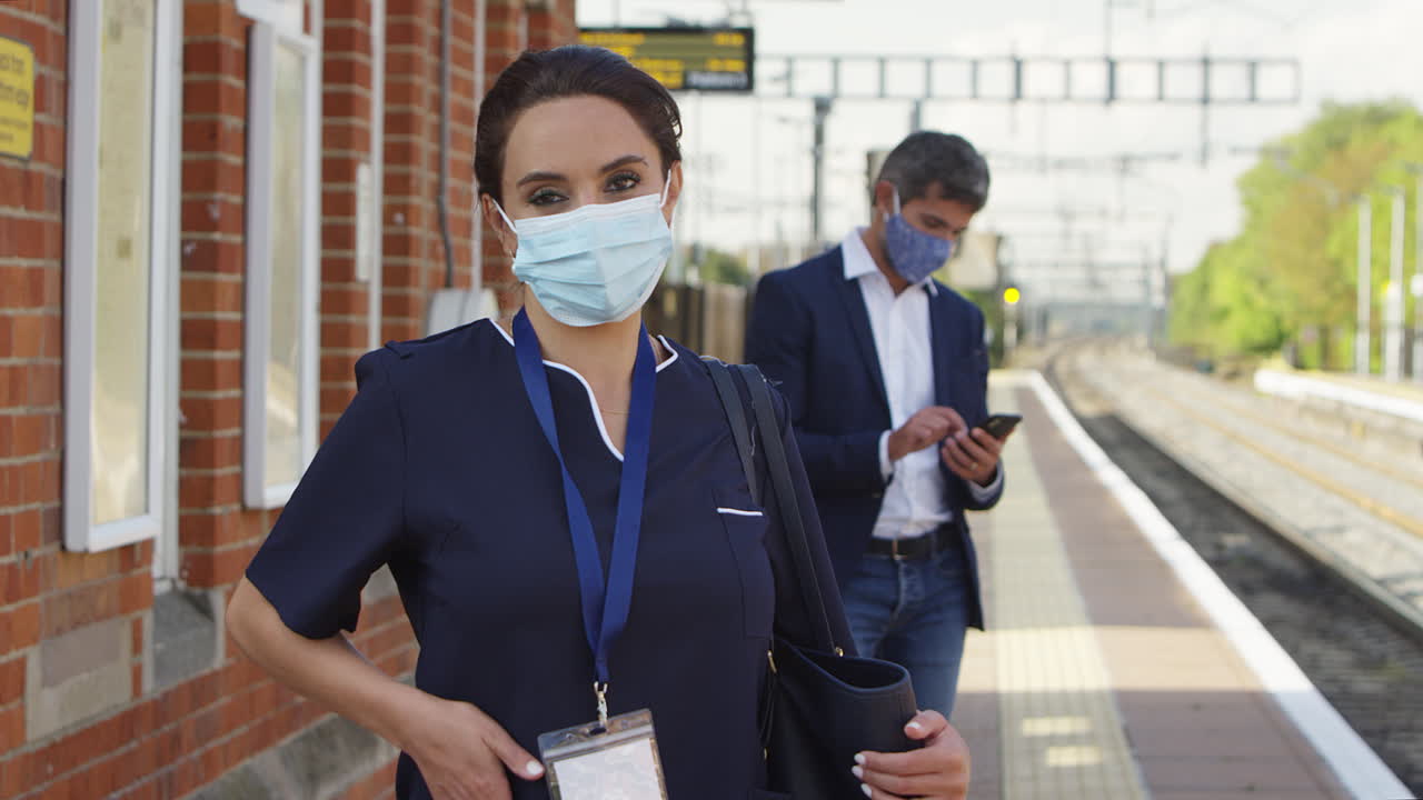 retrato de una enfermera en una plataforma ferroviaria con una máscara facial que viaja al trabajo durante la pandemia
