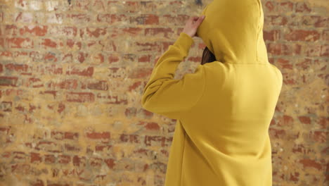 la espalda de una mujer caucásica en una pared de ladrillo