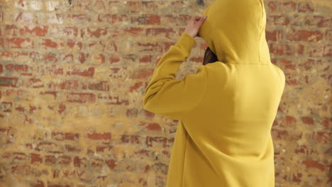 back of caucasian woman on a brick wall