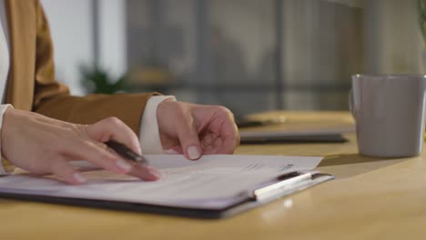 close up of businesswoman in office reviewing and making notes on application or cv for job vacancy 3