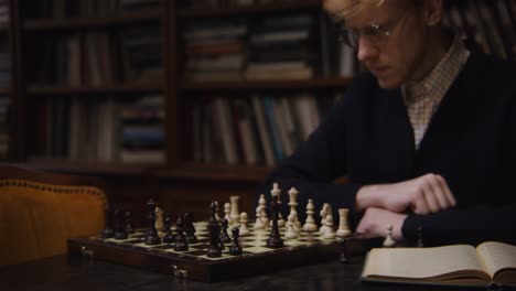 mann spielt schach in einer bibliothek