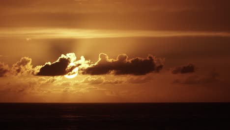 hermoso lapso de tiempo de puesta de sol sobre el mar con cielo naranja y nubes en movimiento