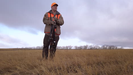 A-Male-Hunter-With-His-Pet-Dog-Preparing-For-Hunting-In-A-Countryside-Farm-In-Saskatchewan,-Canada---Full-Body-Shot