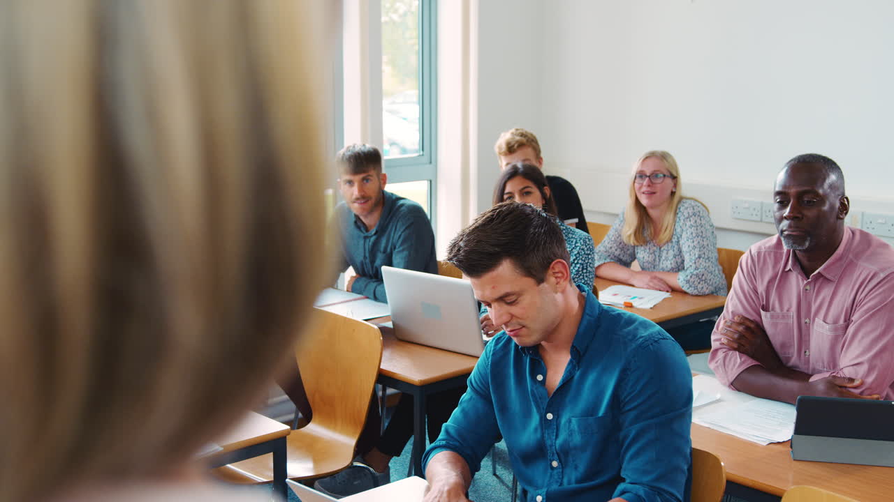 tutora de pie para enseñar a una clase de estudiantes maduros