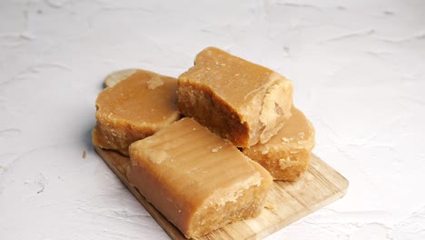 pieces of jaggery on a wooden cutting board