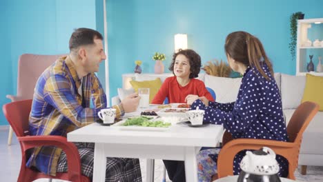 La-Familia-Alegre-Y-Animada-Está-Desayunando-Y-El-Niño-Hace-Reír-A-Su-Familia.