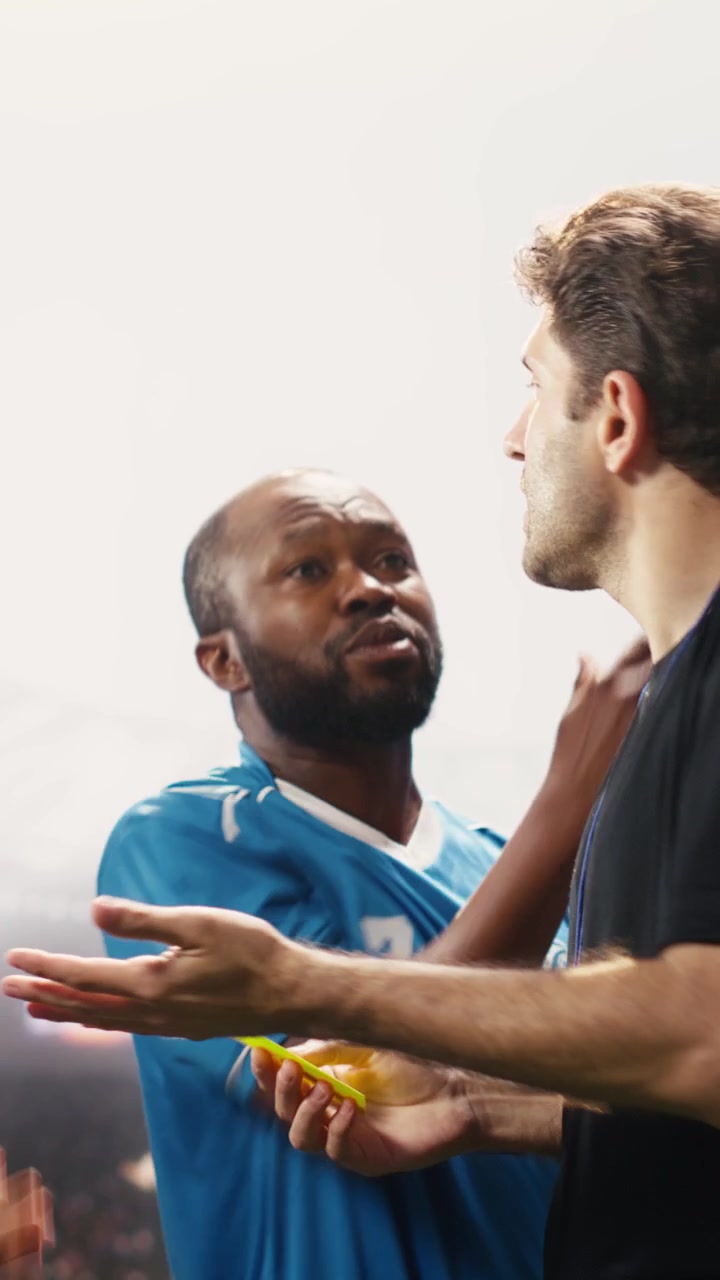 Vertical Video Soccer referee stopping heated argument with yellow card raised