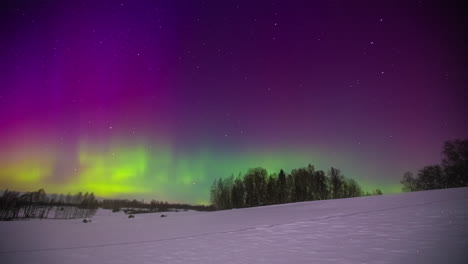 wide shot of white snowy winter fields with colorful flashing northern lights at night sky - time lapse footage