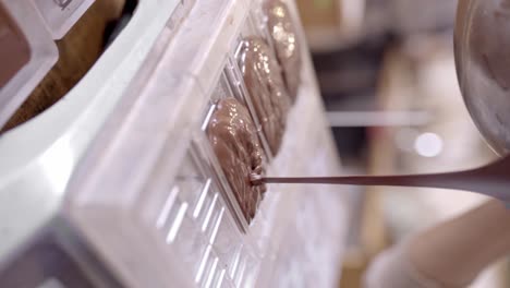 chocolatier de cultivos vertiendo chocolate derretido en forma en la cocina