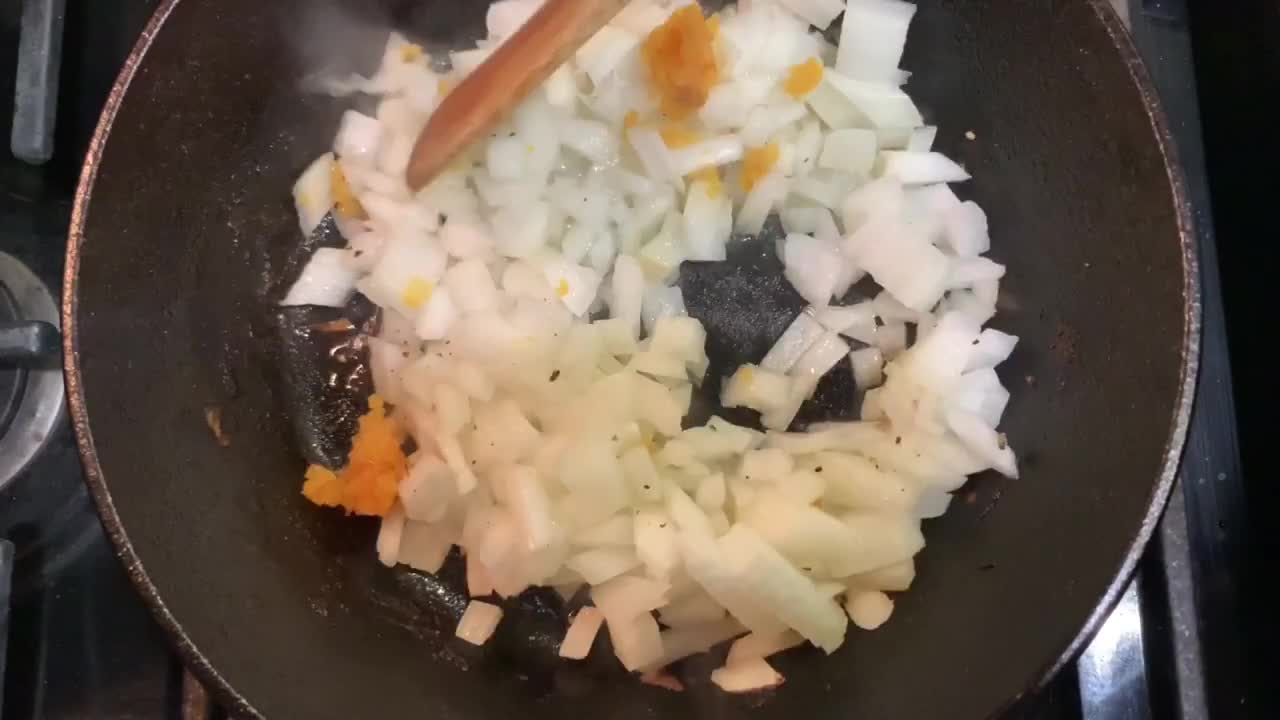 Cooking onions with minced garlic and olive oil over a hot cast iron skillet